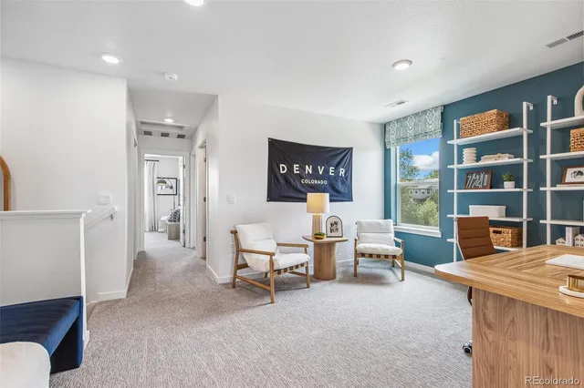 a living room with furniture a rug and a bookshelf