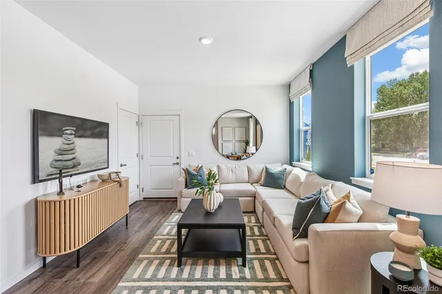 a living room with furniture a flat screen tv and a large window