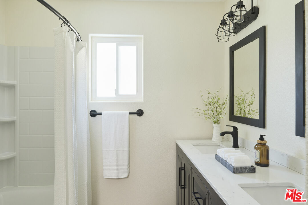 13230 Creekside Lane Poway, CA 92064 - Photo 16 of 23 a bathroom with a sink a mirror and shower