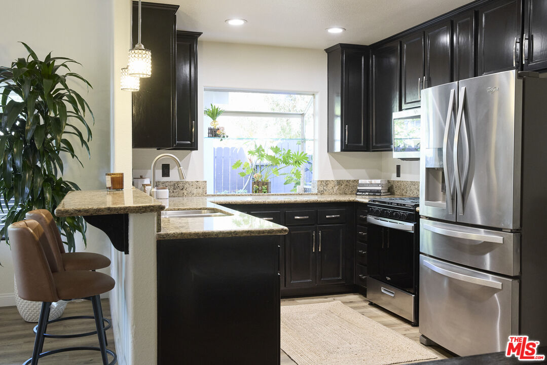 13230 Creekside Lane Poway, CA 92064 - Photo 5 of 23 a kitchen with kitchen island granite countertop a sink stainless steel appliances and cabinets