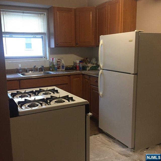 304 B Terrace, Unit 304B Hasbrouck Heights, NJ 07604 - Photo 2 of 2 a white refrigerator freezer and a stove sitting inside of a kitchen