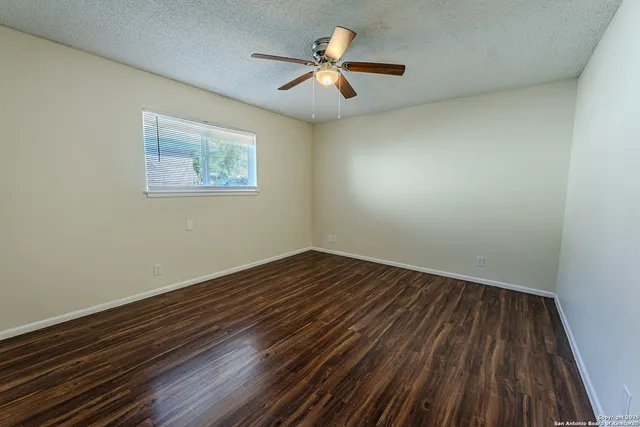 a view of an empty room with wooden floor