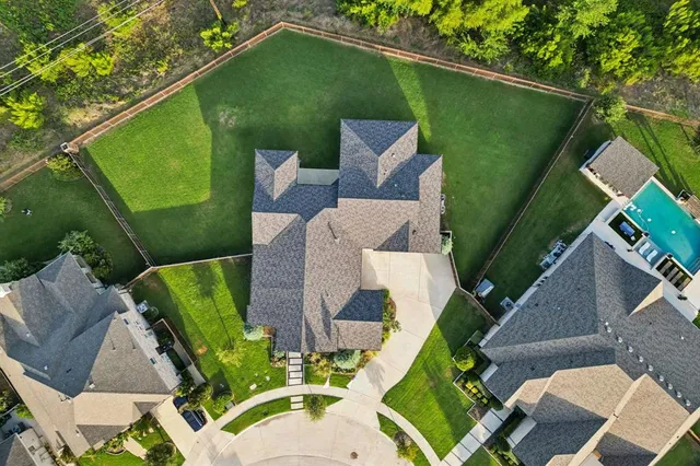 an aerial view of residential houses with outdoor space and ocean view