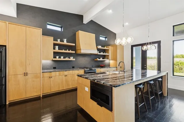 a kitchen with stainless steel appliances granite countertop a sink and a refrigerator