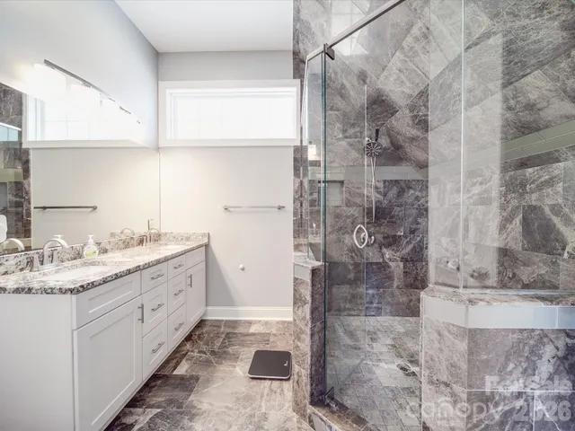 a bathroom with a granite countertop sink mirror and shower