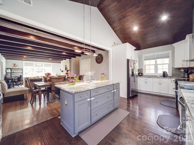a kitchen with granite countertop a stove and a wooden floors