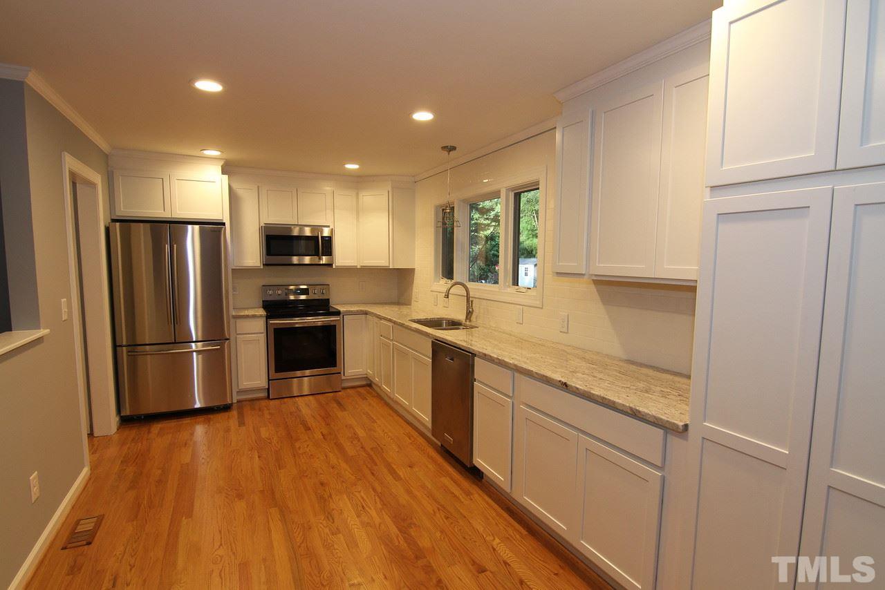 4208 Rowan Street Raleigh, NC 27609 - Photo 3 of 14 a kitchen with stainless steel appliances granite countertop a refrigerator a sink dishwasher a stove and white countertops with wooden floor