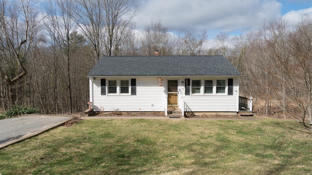 a white house that has a tree in front of it