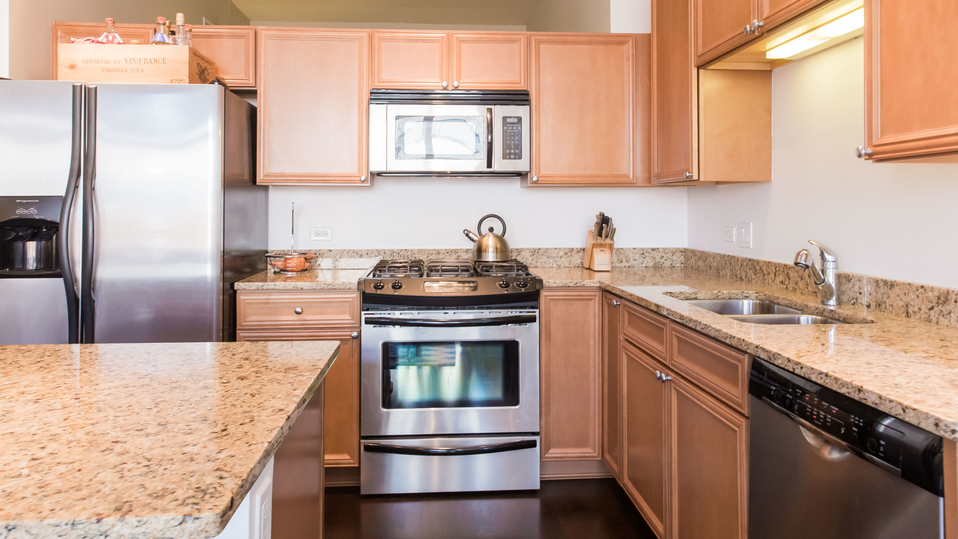 901 West Madison Street, Unit 609 Chicago, IL 60607 - Photo 11 of 22 a kitchen with kitchen island granite countertop a sink stove and refrigerator