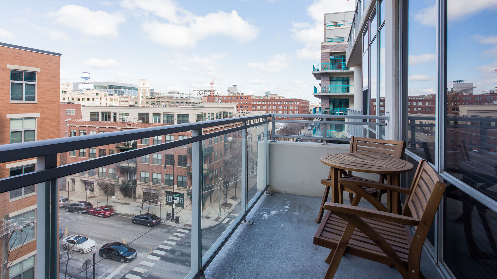 901 West Madison Street, Unit 609 Chicago, IL 60607 - Photo 21 of 22 a view of a balcony with wooden chairs and floor to ceiling window