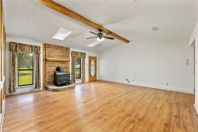 a kitchen with stainless steel appliances granite countertop a refrigerator a sink dishwasher a stove and white countertops with wooden floor