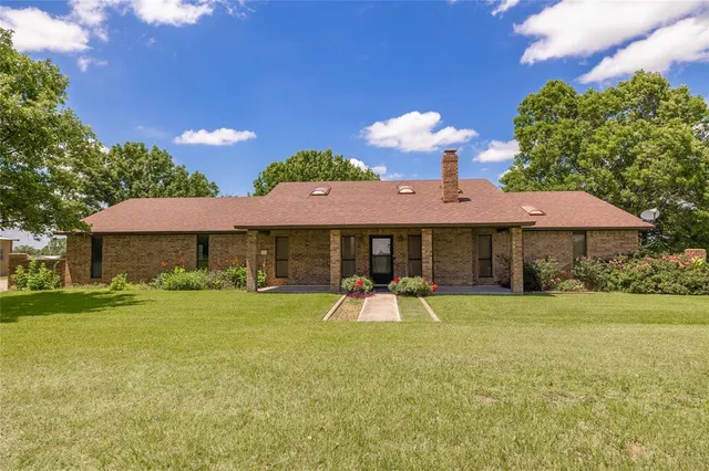 a view of a house with a yard and sitting area