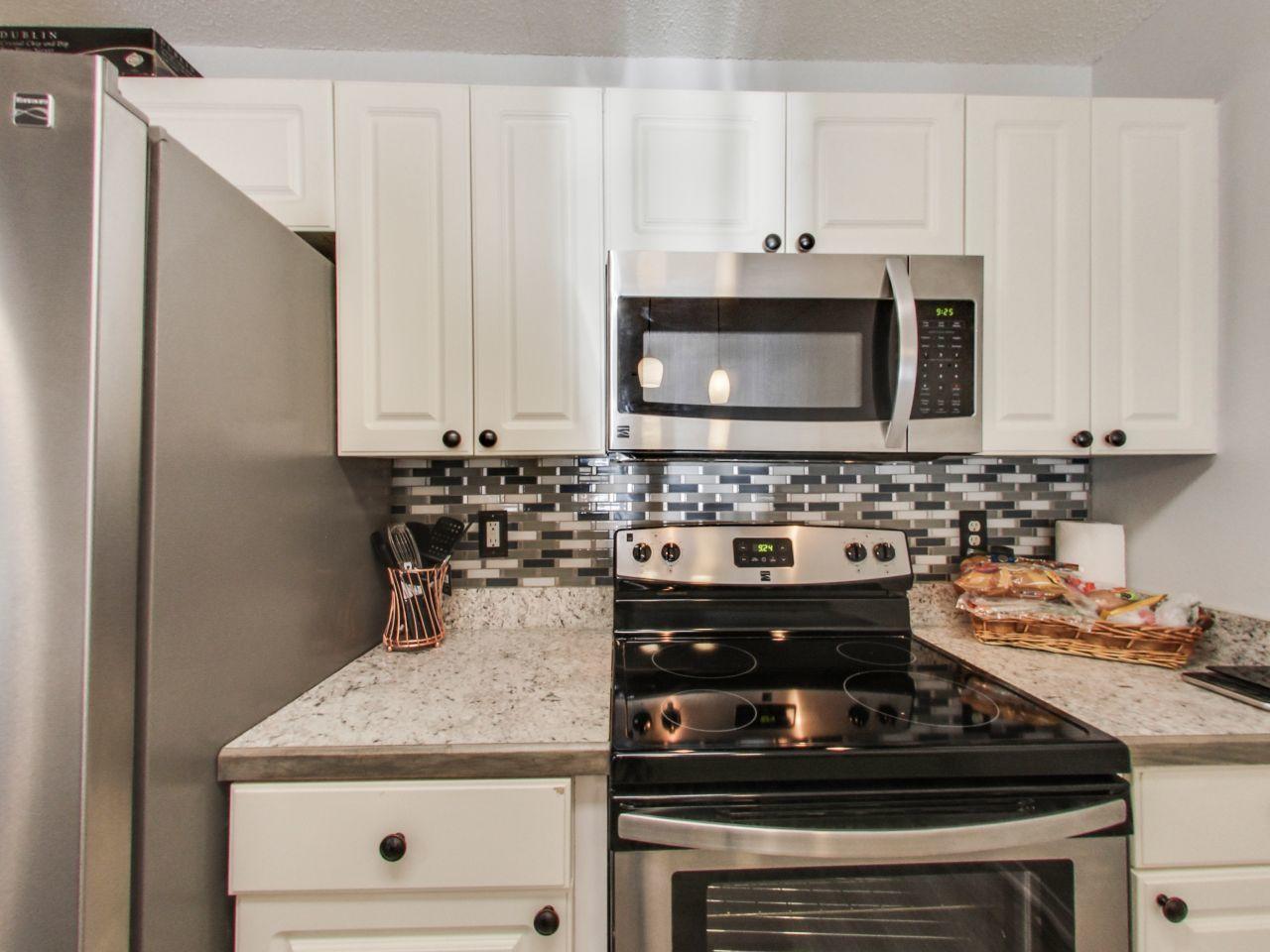 487 Keystone Road, Unit 487 Mary Esther, FL 32569 - Photo 11 of 28 a kitchen with granite countertop a stove sink and microwave