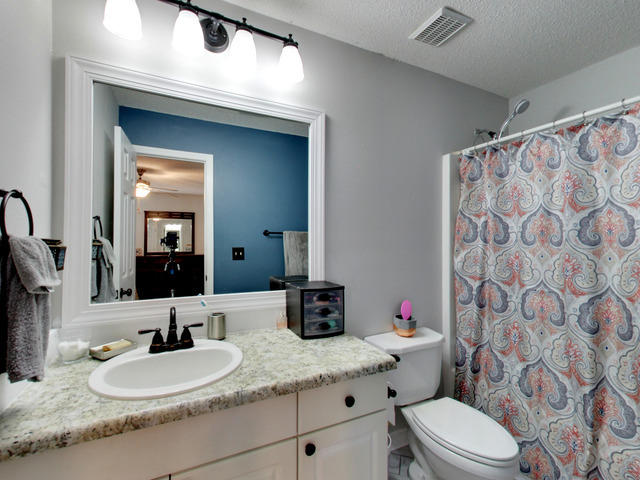 487 Keystone Road, Unit 487 Mary Esther, FL 32569 - Photo 20 of 28 a bathroom with a granite countertop toilet sink mirror and shower