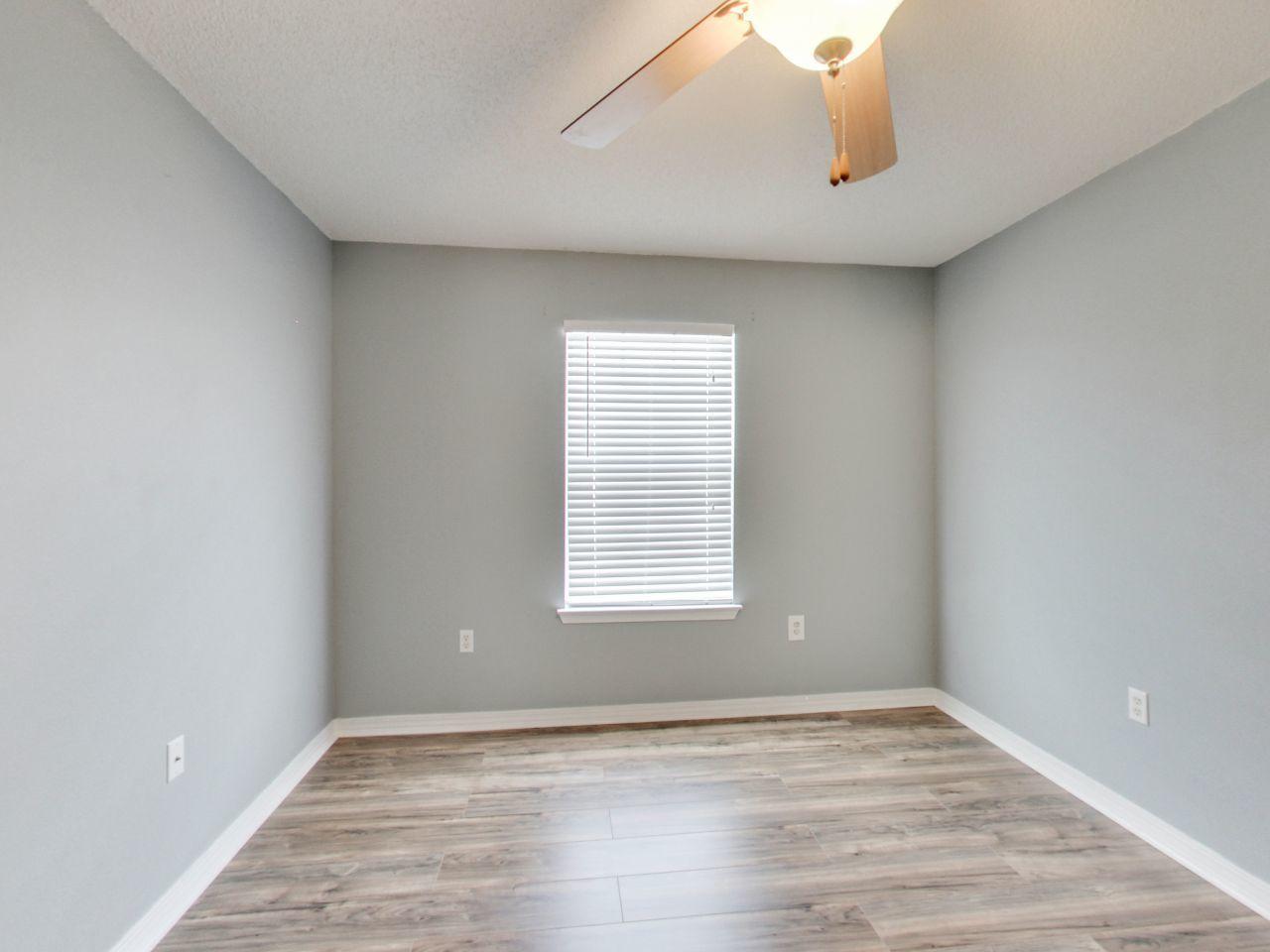 487 Keystone Road, Unit 487 Mary Esther, FL 32569 - Photo 21 of 28 a view of an empty room with wooden floor and a window