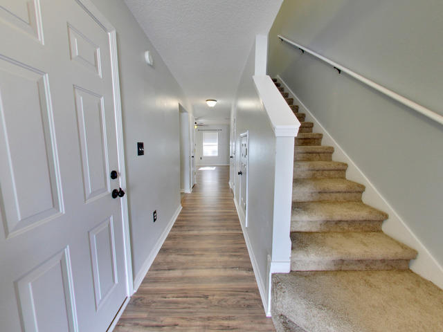 487 Keystone Road, Unit 487 Mary Esther, FL 32569 - Photo 4 of 28 a view of a hallway with wooden floor and staircase