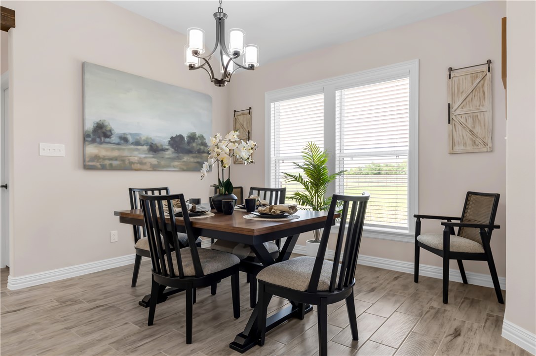 3310 Hunters Crossing Bryan, TX 77808 - Photo 17 of 34 Dining area with wood tiled floors and a chandelier