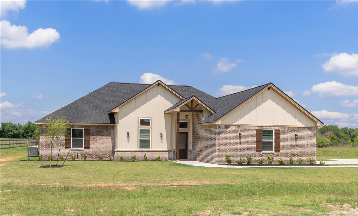 3310 Hunters Crossing Bryan, TX 77808 - Photo 2 of 34 View of front of home with brick siding, board and batten siding, and roof with shingles