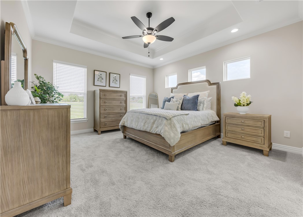 3310 Hunters Crossing Bryan, TX 77808 - Photo 21 of 34 Bedroom with a tray ceiling, light carpet, a ceiling fan, and ornamental molding