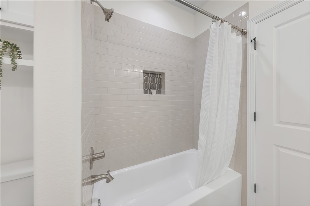 3310 Hunters Crossing Bryan, TX 77808 - Photo 29 of 34 Bathroom featuring shower / bath combo with shower curtain and toilet