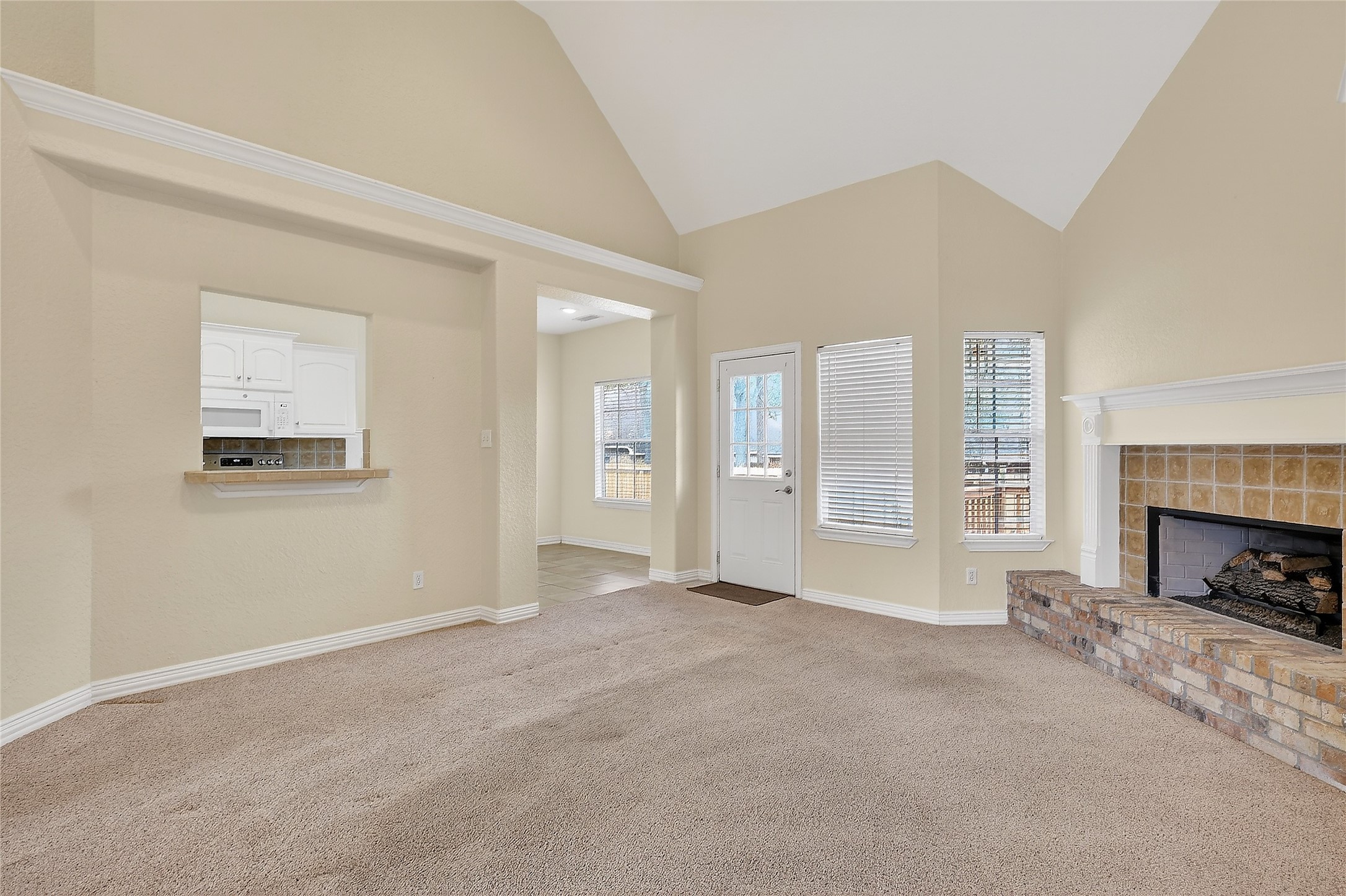 89 Dawns Edge Conroe, TX 77356 - Photo 21 of 46 Light-filled living space features vaulted ceilings, brick fireplace, and seamless access to the kitchen.