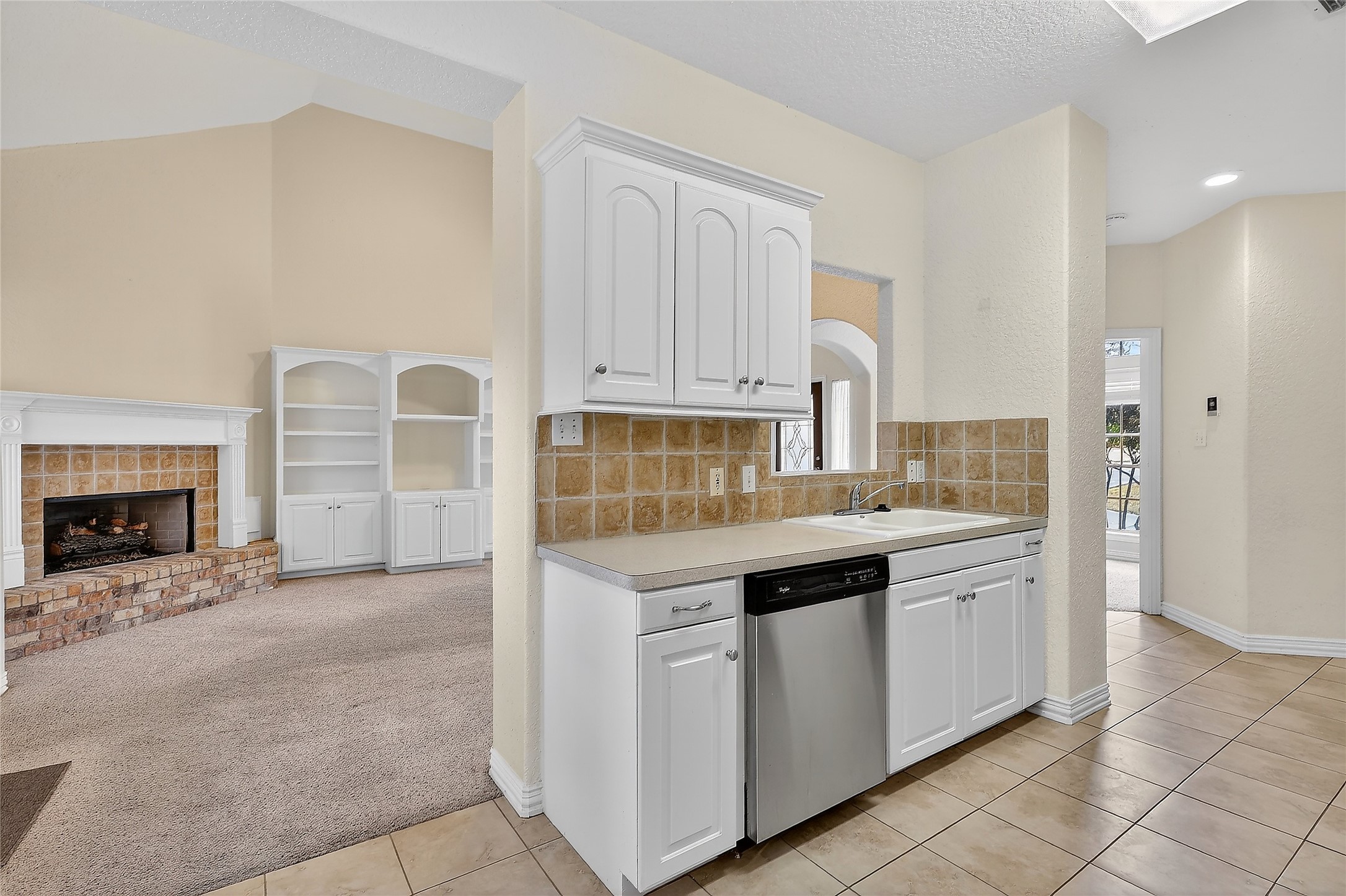 89 Dawns Edge Conroe, TX 77356 - Photo 22 of 46 Bright kitchen workspace with generous cabinet storage, tile accents, and adjacent access to the home’s central living area.