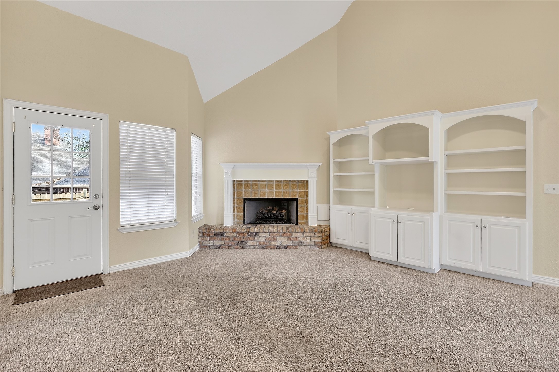 89 Dawns Edge Conroe, TX 77356 - Photo 7 of 46 Bright and versatile living room designed for everyday comfort, featuring a statement fireplace and integrated shelving.