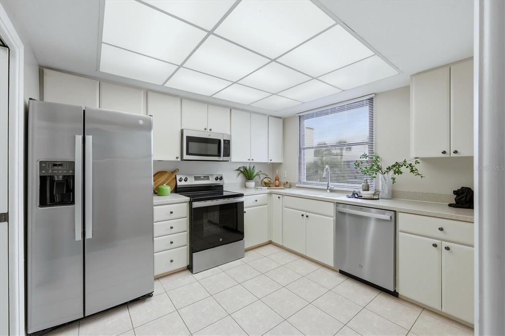 5058 Marsh Field Road, Unit 8 Sarasota, FL 34235 - Photo 12 of 73 a kitchen with white cabinets stainless steel appliances and a window