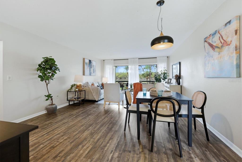 5058 Marsh Field Road, Unit 8 Sarasota, FL 34235 - Photo 5 of 73 a view of a dining room and livingroom with furniture wooden floor a chandelier