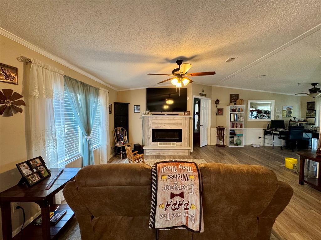 19580 Northwest 80th Drive Okeechobee, FL 34972 - Photo 26 of 34 a living room with furniture a flat screen tv and a fireplace