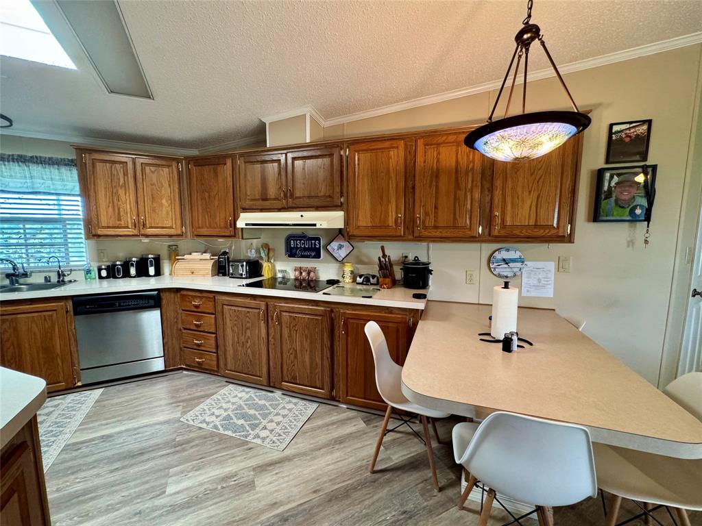 19580 Northwest 80th Drive Okeechobee, FL 34972 - Photo 27 of 34 a kitchen with a table chairs a sink dishwasher and cabinets
