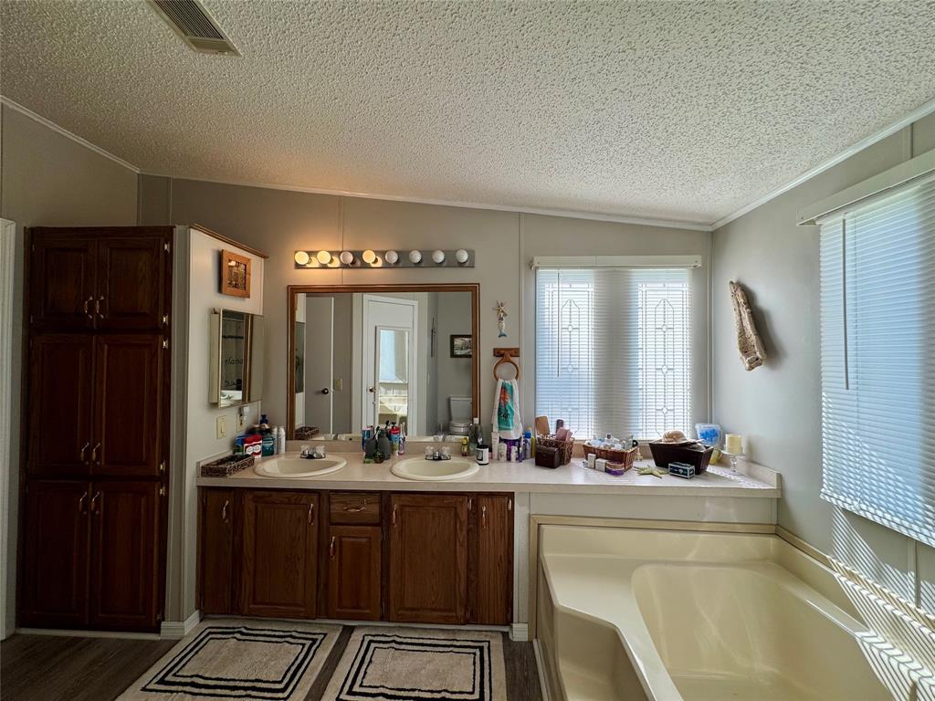 19580 Northwest 80th Drive Okeechobee, FL 34972 - Photo 33 of 34 a bathroom with a double vanity sink and a mirror