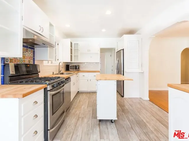 a kitchen with a sink a stove and cabinets
