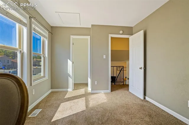 a view of a hallway with a bathroom and a sink