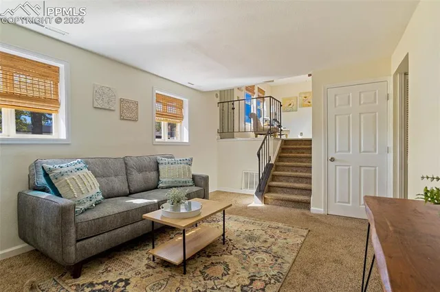 a living room with furniture and stairs