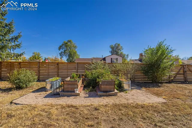 a view of a patio with table and chairs and potted plants with wooden fence