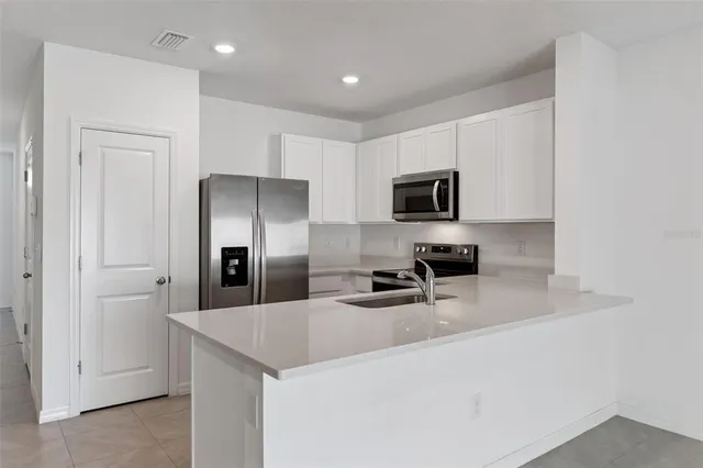a kitchen with granite countertop a refrigerator and a sink