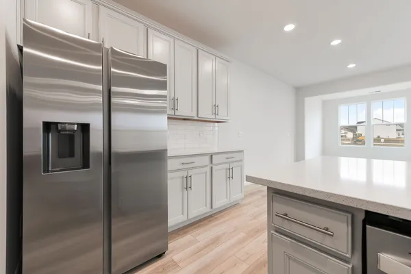 a kitchen with cabinets and a refrigerator