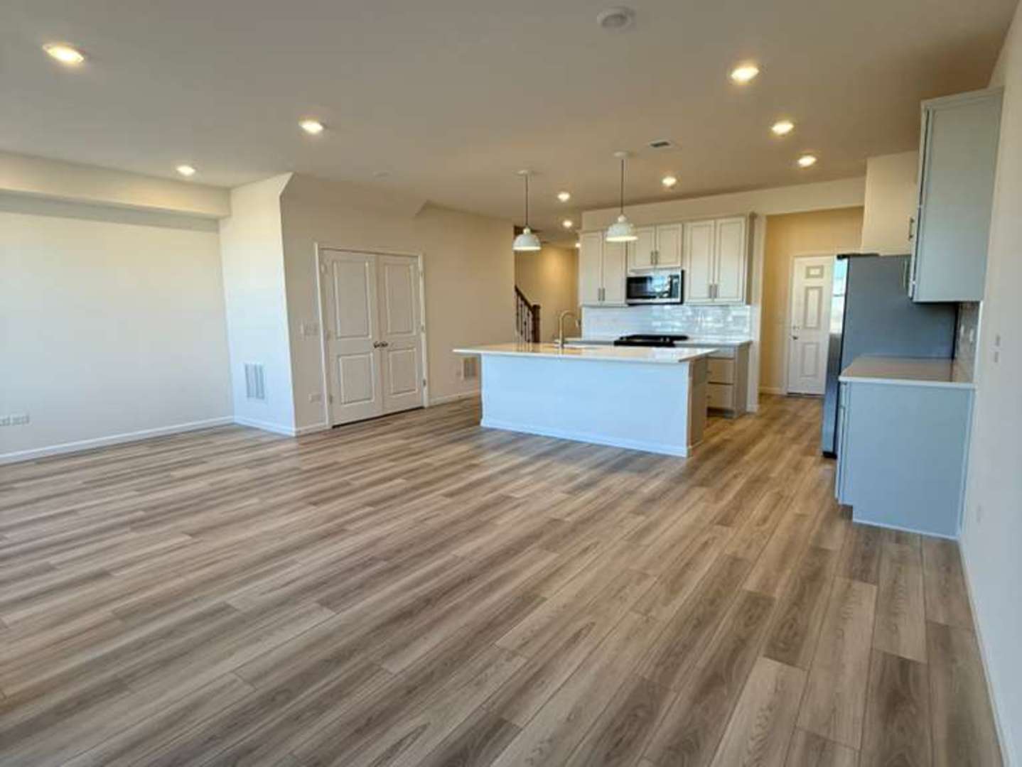 672 Switchgrass Way, Unit 58005 Bolingbrook, IL 60490 - Photo 6 of 19 a large kitchen with stainless steel appliances kitchen island granite countertop a large counter top and a stove top oven