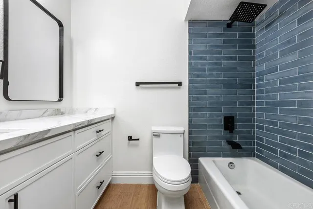 a bathroom with a granite countertop toilet a sink and bathtub