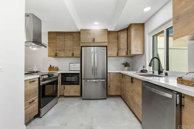 a kitchen with a sink cabinets stainless steel appliances and a window