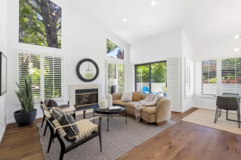 a living room with furniture a large window and a fireplace