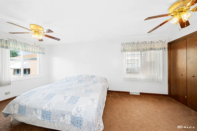 a bedroom with a bed a chandelier and a window