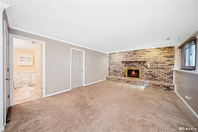 a view of an empty room with fireplace and a window