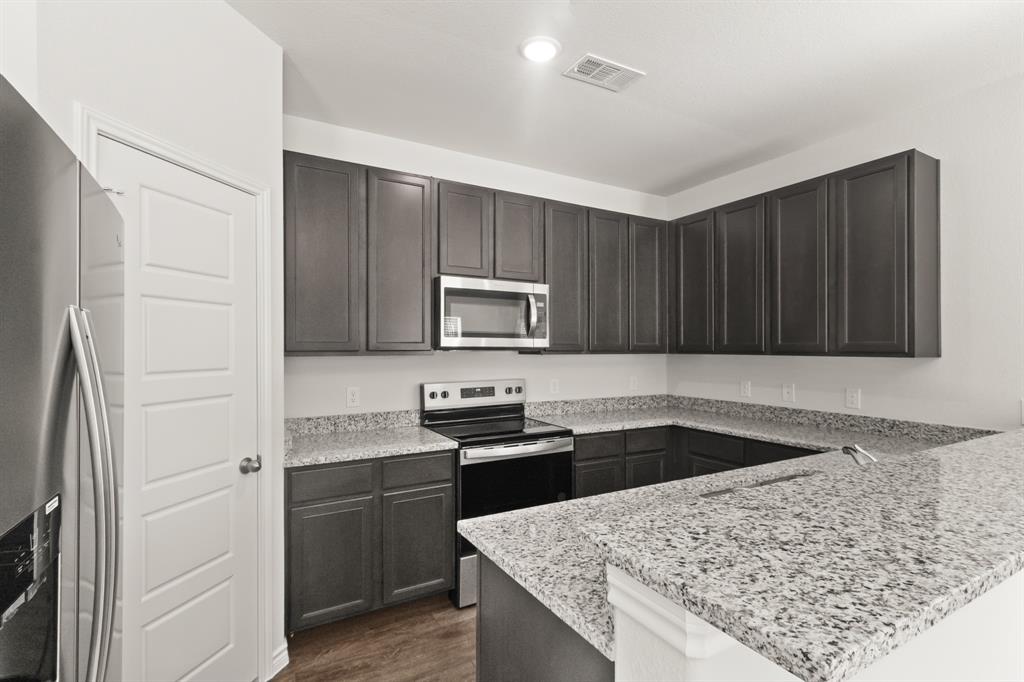 1505 Romans Road Ennis, TX 75119 - Photo 5 of 13 a kitchen with a sink stove and refrigerator