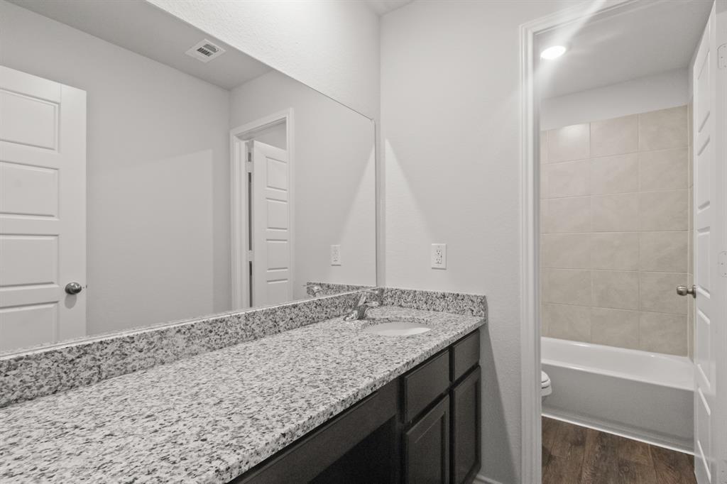 1505 Romans Road Ennis, TX 75119 - Photo 10 of 13 a bathroom with a granite countertop sink and a bathtub