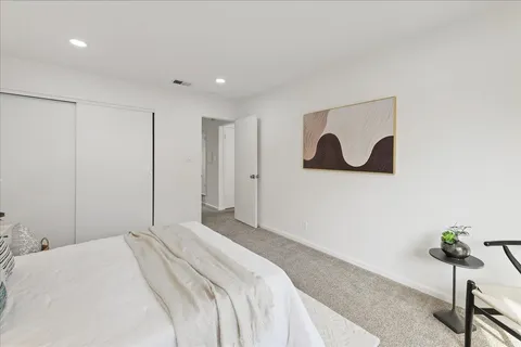 a bedroom with a bed and painting on the wall