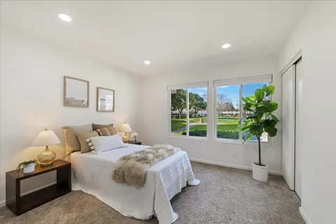 a bedroom with a bed and a potted plant