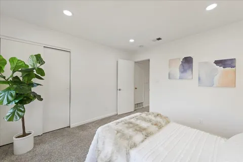 a bedroom with a bed and a potted plant