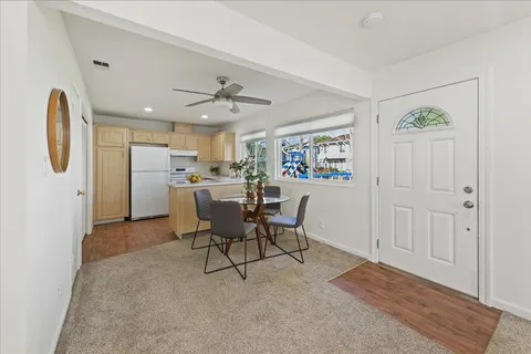 a view of a kitchen and a dining room with furniture window and wooden floor